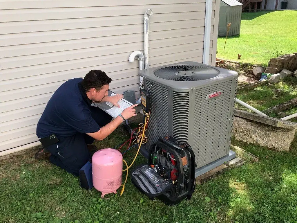 HVAC technician servicing residential air conditioning unit -Dryer Vent Cleaning Odenville