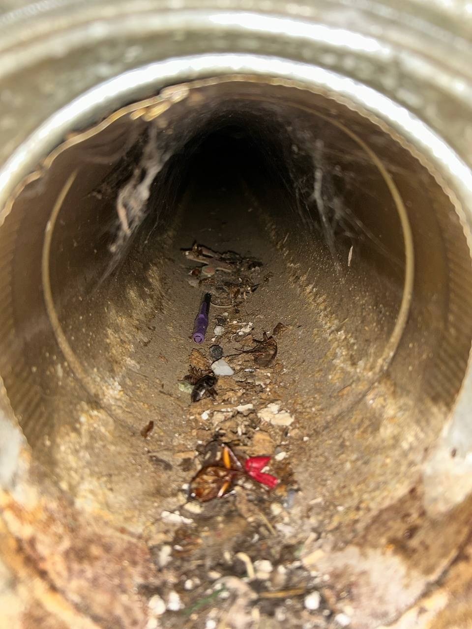 Dirty air duct before cleaning -- debris and years of buildup inside